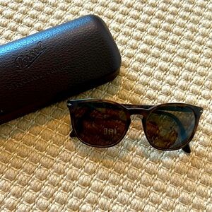 Persol matte tortoise rounded sunglasses with brown case and cleaning cloth.